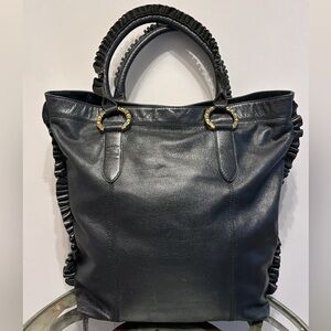BCBGGirls black leather handbag hand held ruffled handles brass rings